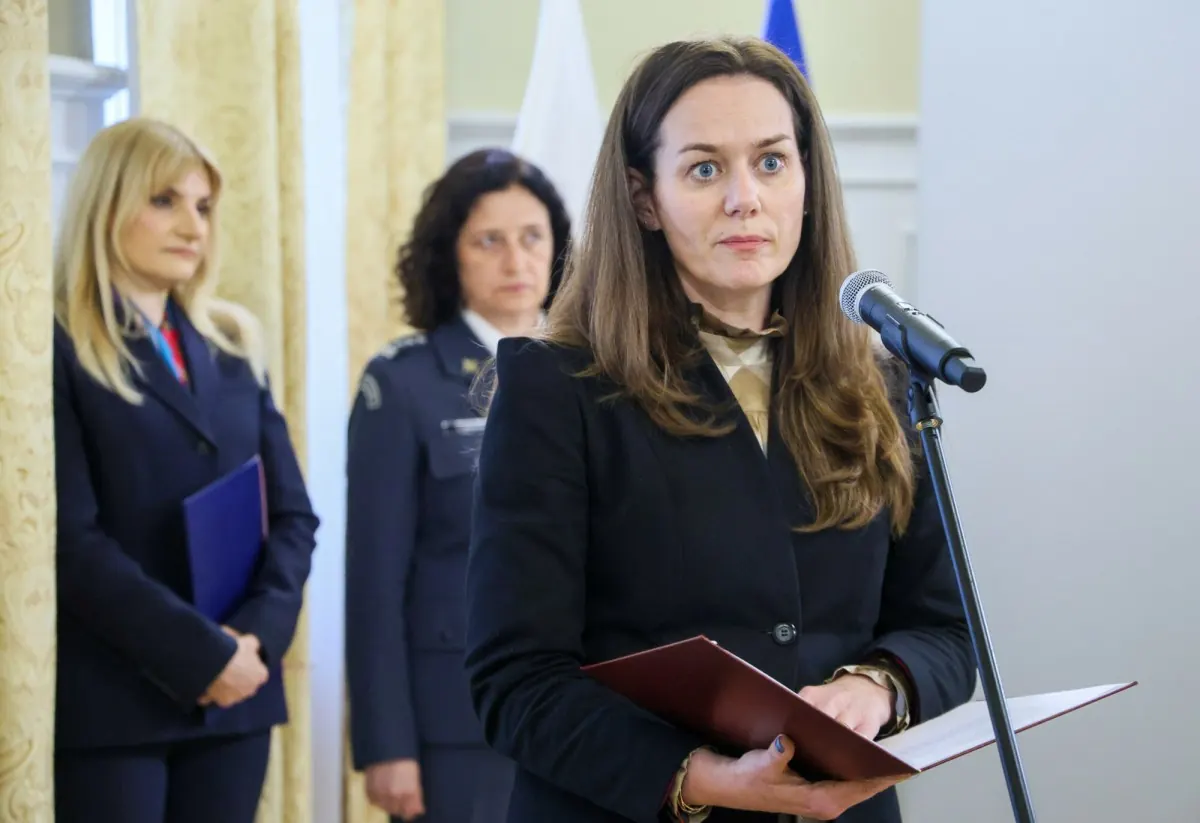 Wiceminister sprawiedliwości Maria Ejchart podczas konferencji prasowej, w tle budynek aresztu śledczego.