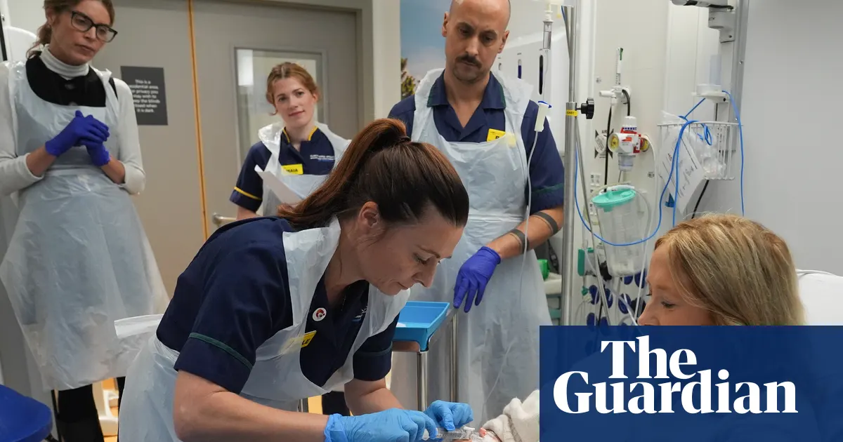 Katie Tinkler, pacjentka z toczniem, która osiągnęła remisję po terapii CAR T-komórkowej, stoi i uśmiecha się przed University College London Hospital.
