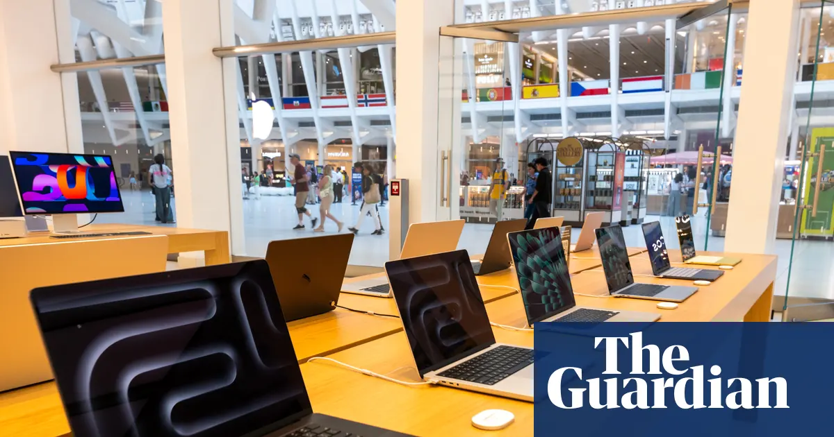 Produkty Apple na wystawie w sklepie, z widocznymi iPadami i MacBookami.