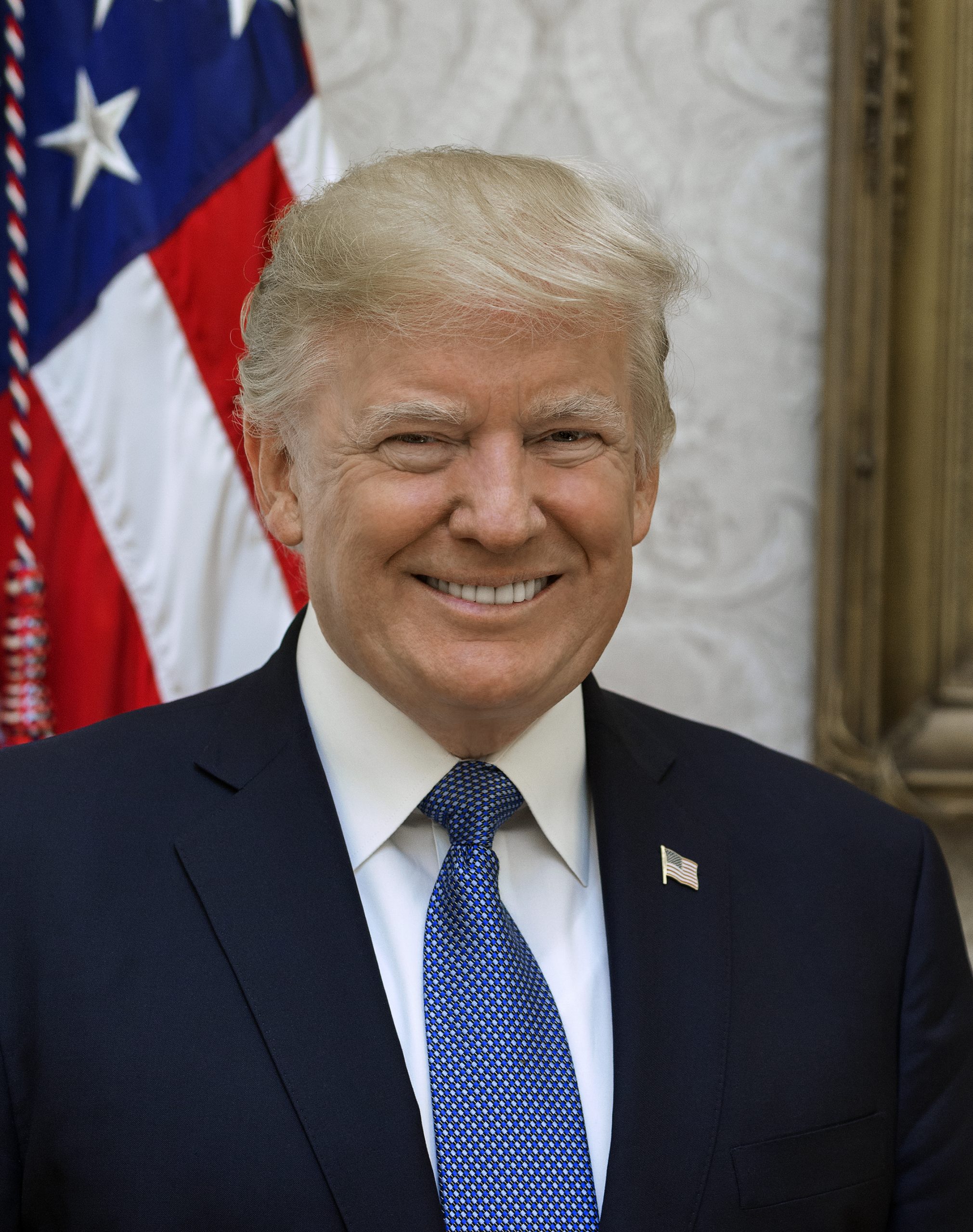 Donald Trump przemawiający na tle flag amerykańskich