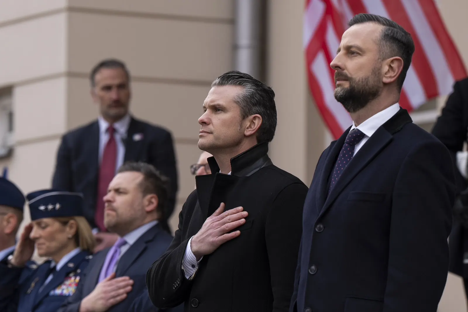 Władysław Kosiniak-Kamysz, Wicepremier i Minister Obrony Narodowej, podczas oficjalnego wydarzenia, z symbolami polskiej flagi w tle.