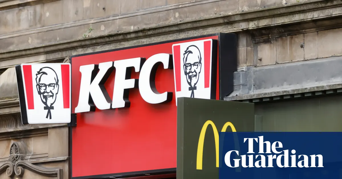 Zdjęcie przedstawiające dzieci wychodzące ze szkoły, w tle widoczna restauracja fast food.