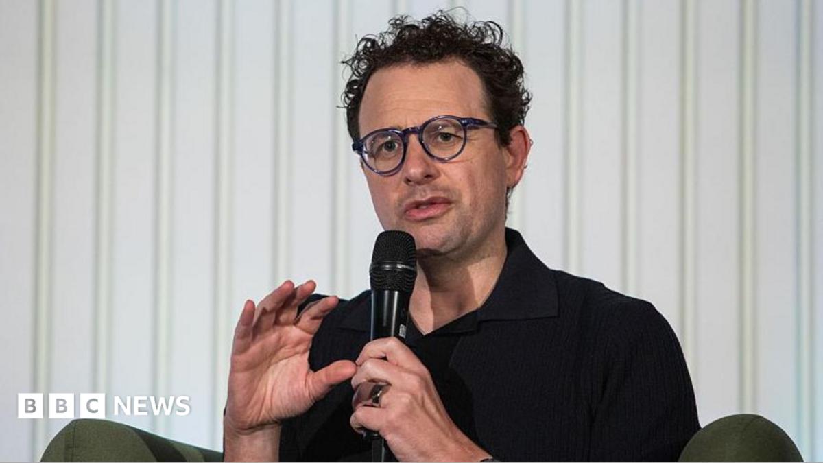 Dyrektor generalny Anthropic Dario Amodei na tle konferencji technologicznej