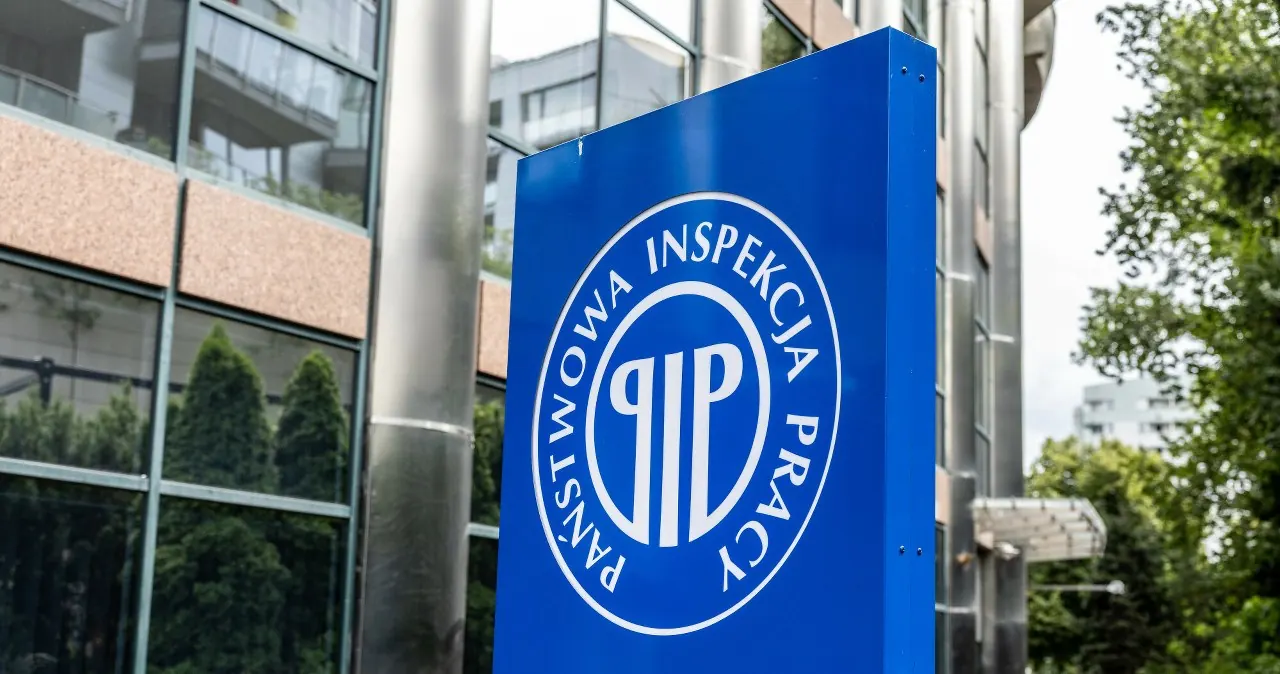 Inspektor Państwowej Inspekcji Pracy podczas kontroli dokumentów pracowniczych w firmie