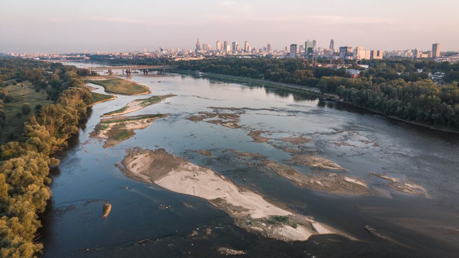 Odsłonięte piaszczyste dno rzeki w Polsce w okresie letniej suszy hydrologicznej.