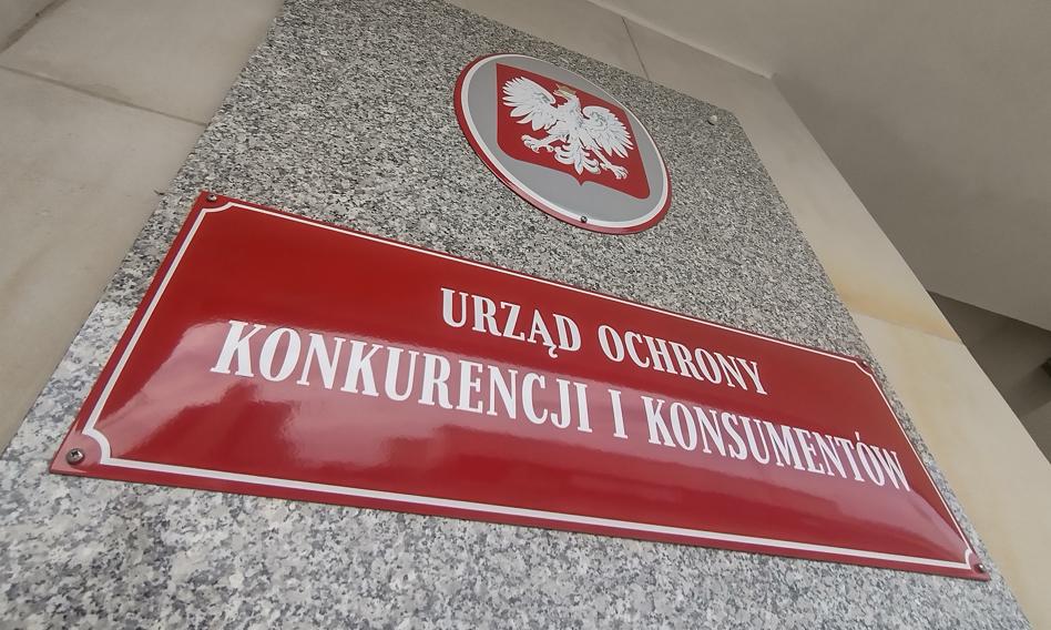 Budynek siedziby UOKiK w Warszawie, przed którym stoi tablica z nazwą urzędu
