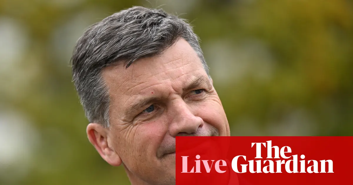 Lider australijskiej opozycji Angus Taylor przemawiający na konferencji prasowej na tle flagi Australii