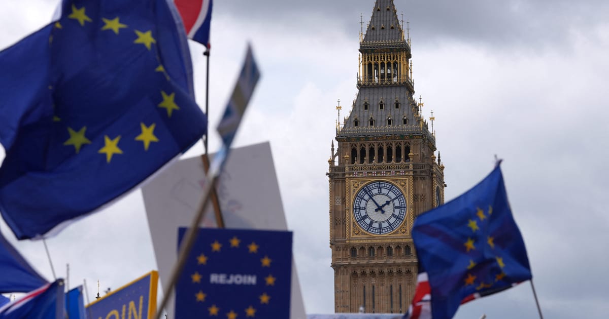 Flagi Wielkiej Brytanii i Unii Europejskiej na tle budynku parlamentu w Londynie. Zdjęcie ilustracyjne.