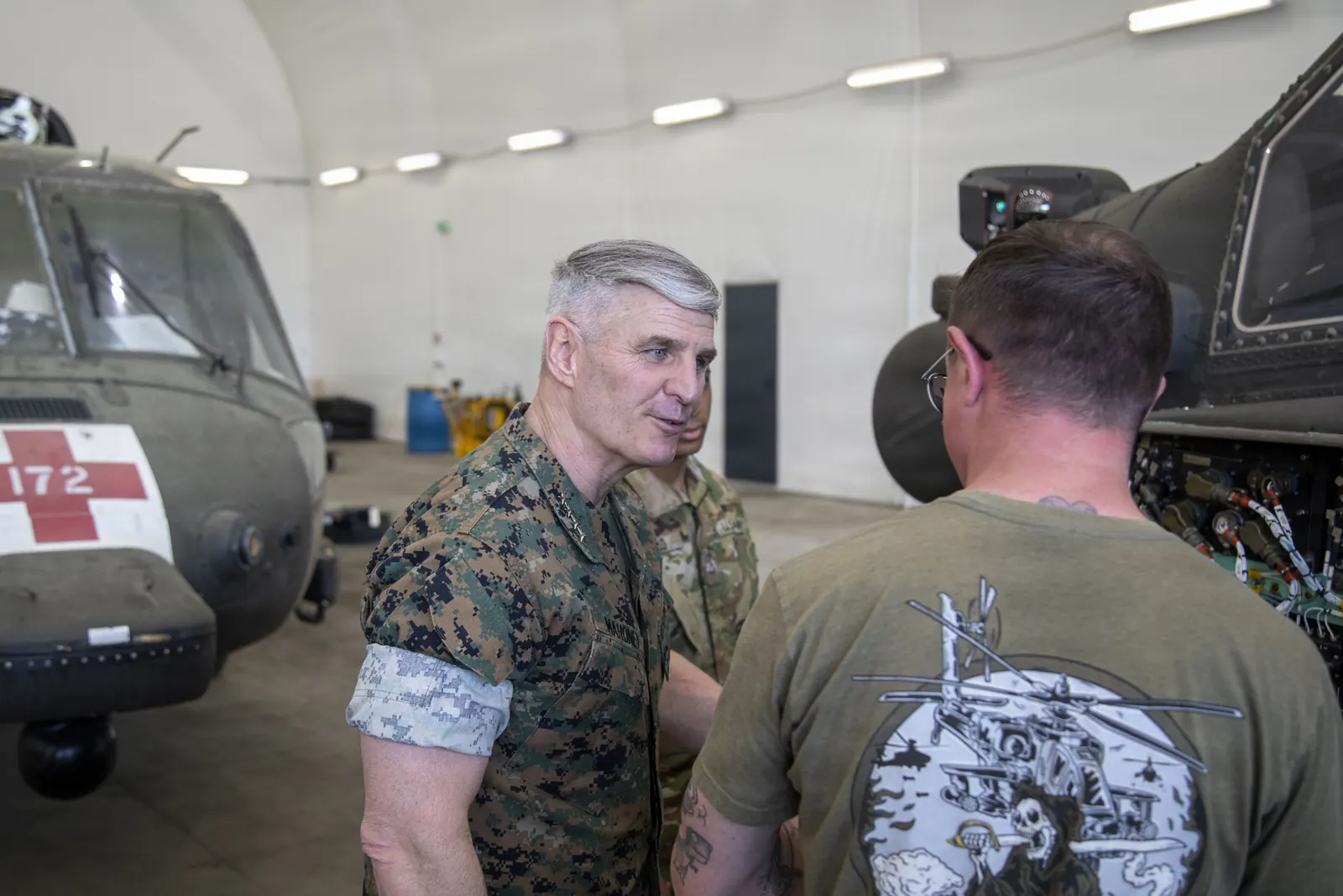 Spotkanie przedstawicieli wojskowych i flaga USA w kontekście współpracy obronnej