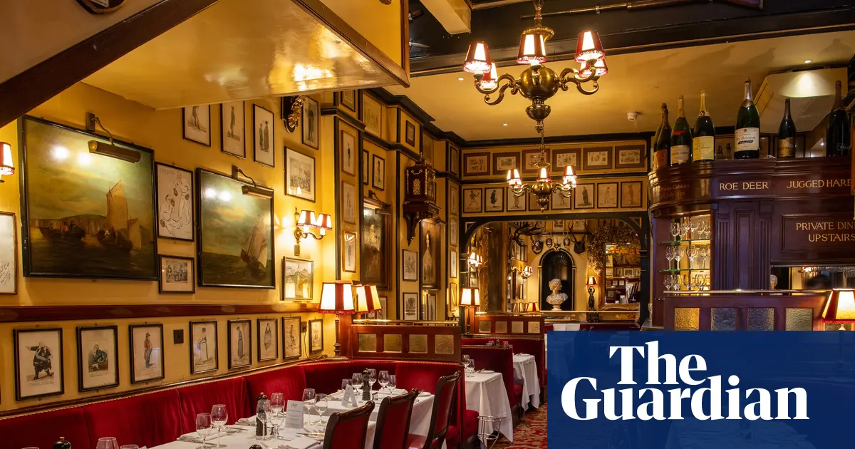Wnętrze restauracji Rules w Londynie z historycznymi dekoracjami i vintage'owymi plakatami teatralnymi