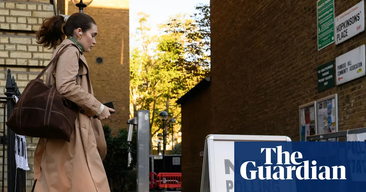 Kobieta przechodzi obok lokalu wyborczego w Primrose Hill w Londynie podczas wyborów uzupełniających w okręgu Holborn and St Pancras