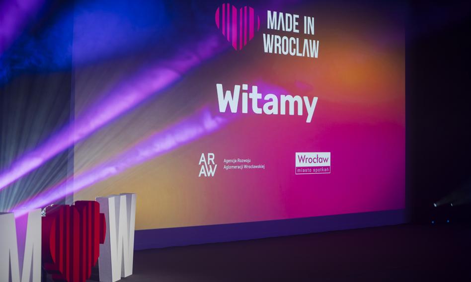 Hala Stulecia we Wrocławiu podczas konferencji Made in Wroclaw, na scenie prelegent, w tle stoiska EXPO z nowymi technologiami